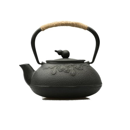 petite théière en fonte noire sur un fond blanc