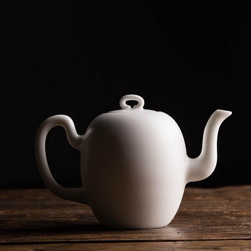 petite théière en céramique blanche sur fond noir