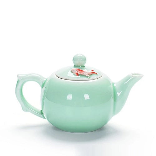 Petite théière en porcelaine verte avec poisson rouge