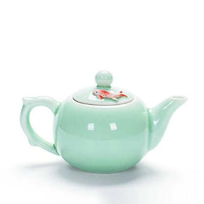 Petite théière en porcelaine verte avec poisson rouge