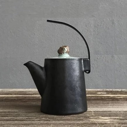 Théière en céramique japonaise avec anse incurvée sur une table