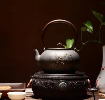 Théière en fonte noire fleurs de bambou sur un réchaud
