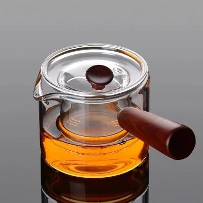theiere en verre avec manche sur fond gris