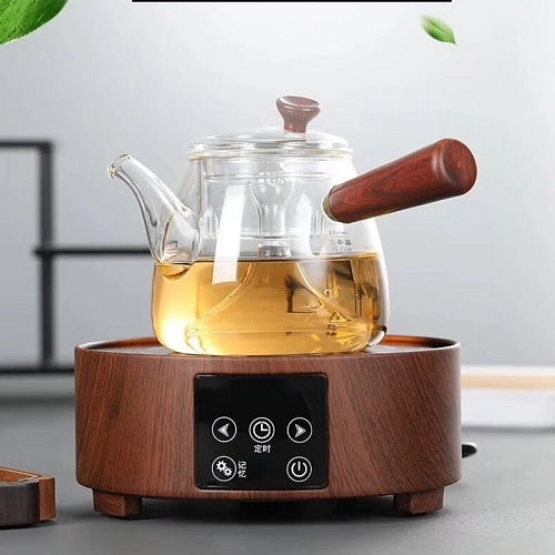 Théière en verre avec manche en bois sur un réchaud