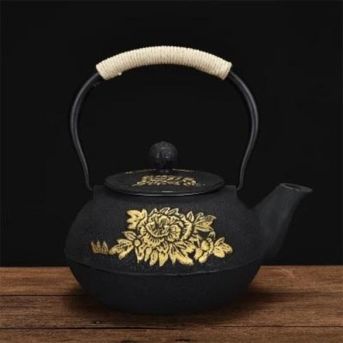 théière en fonte noire fleure dorée vue de coté